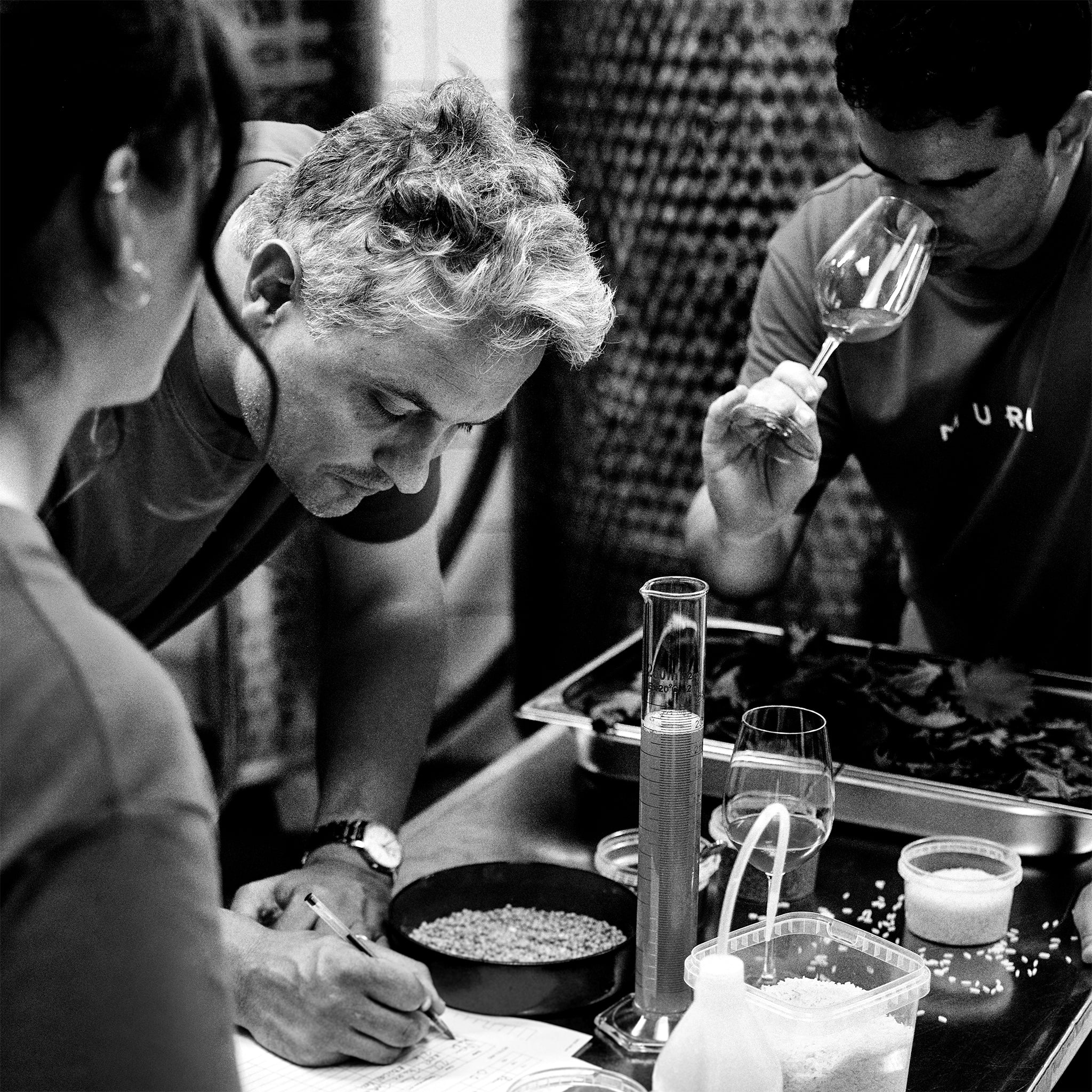 Recipe development session with person writing down recipe and others discussing