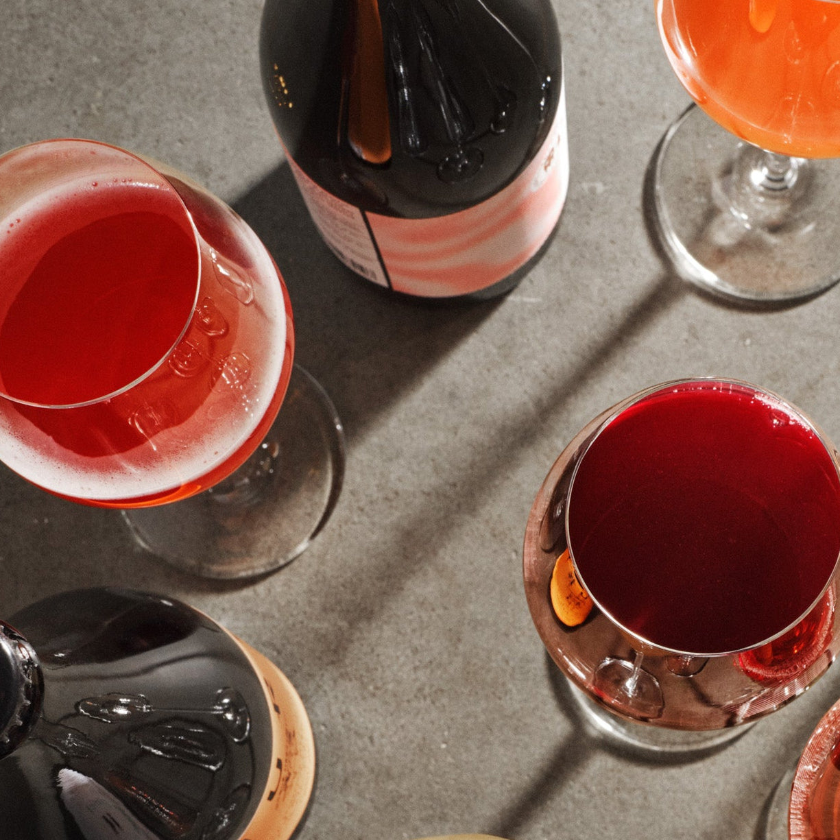 Assorted glasses of colorful drinks on a gray surface